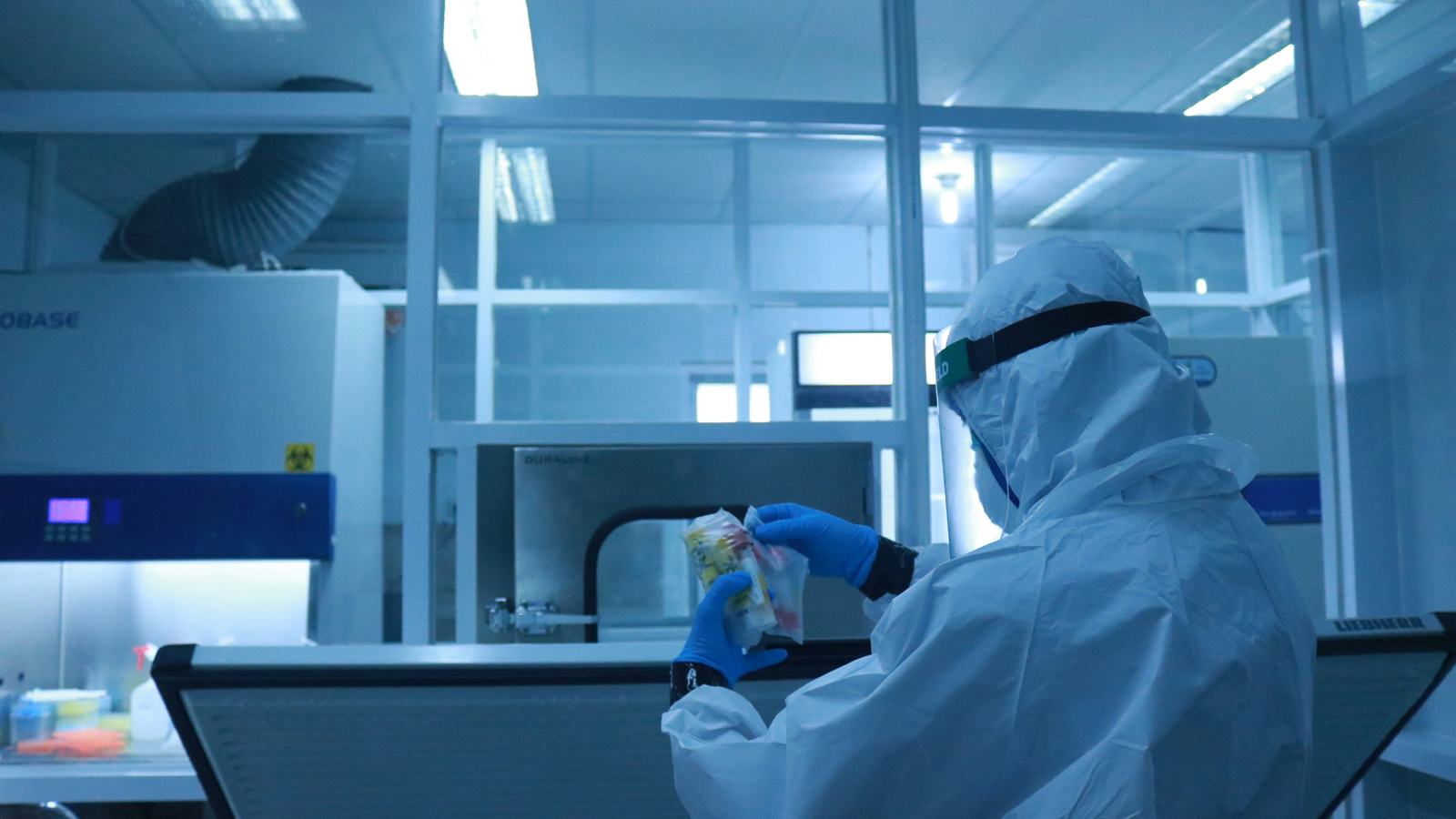 Technician in full protective gear working inside a controlled cleanroom